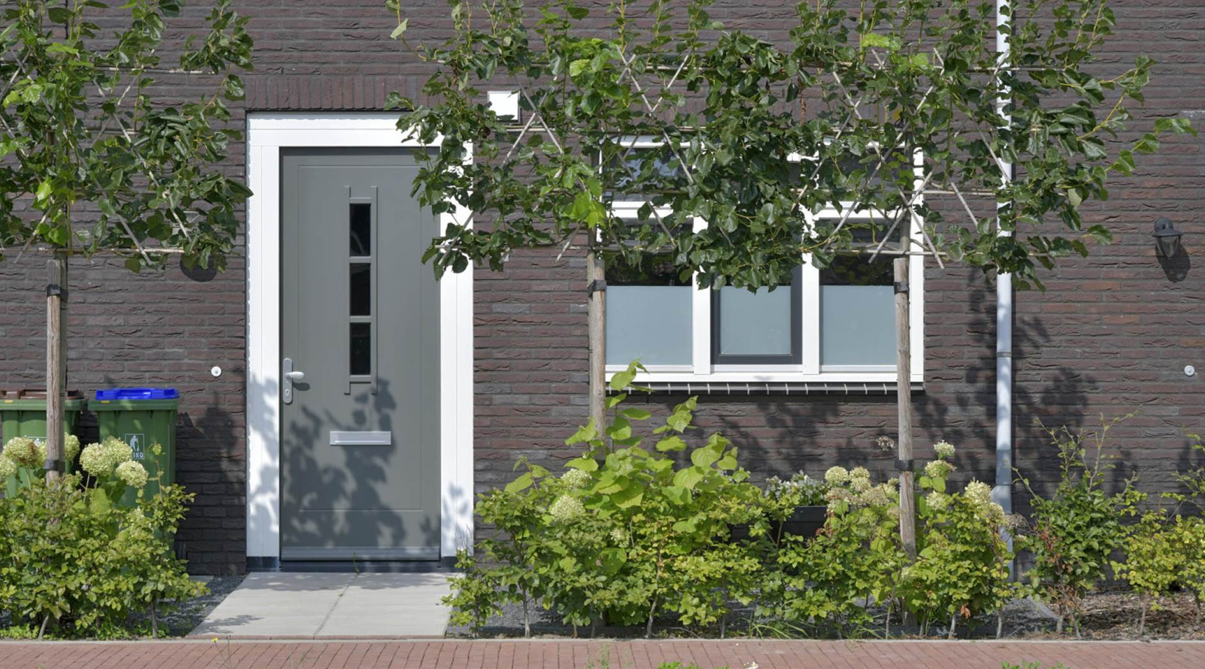 Vooraanzicht van buiten van een benedenverdieping van een huis (voordeur en raam)